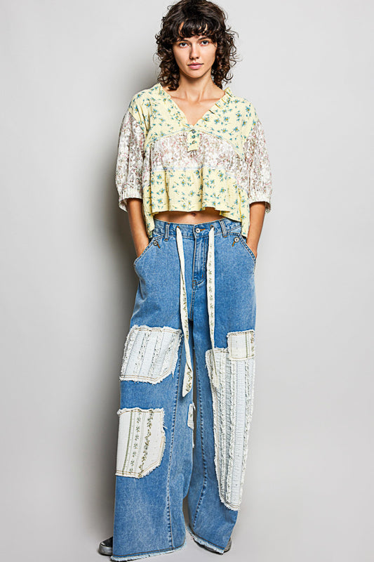 Women wearing a yellow floral and lace design top. 