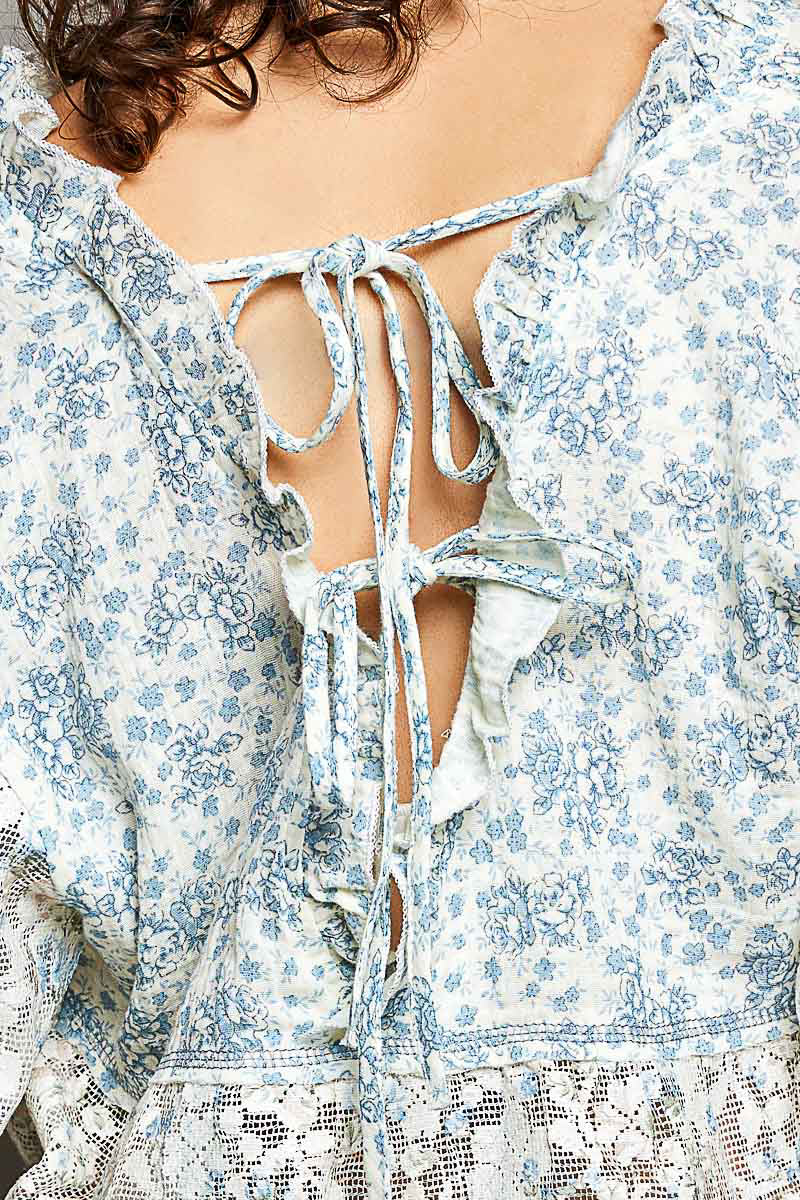 Close-up of a floral dress with a tie-back detail.