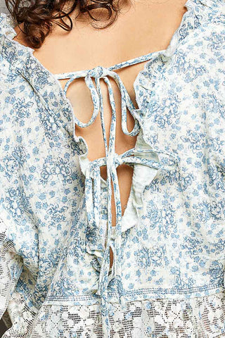 Close-up of a floral dress with a tie-back detail.