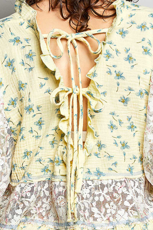 Women wearing a yellow floral and lace design top. 