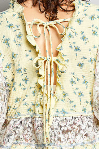 Women wearing a yellow floral and lace design top. 