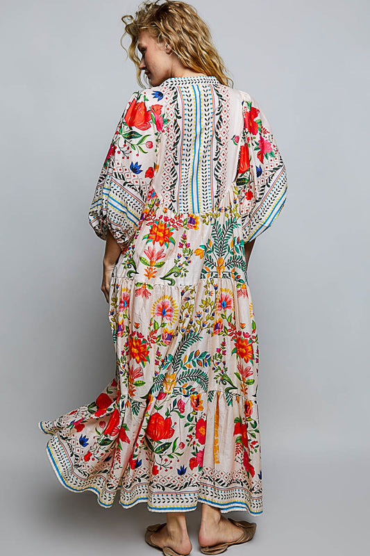 Woman wearing a colorful floral dress with a plain background
