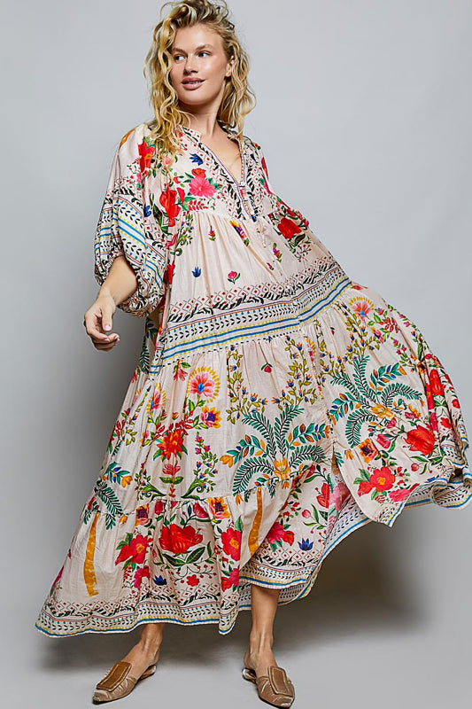 Woman wearing a floral embroidered dress on a plain background
