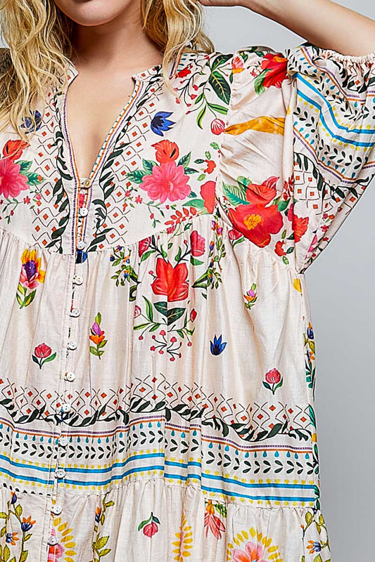 Woman wearing a floral dress with colorful patterns on a gray background