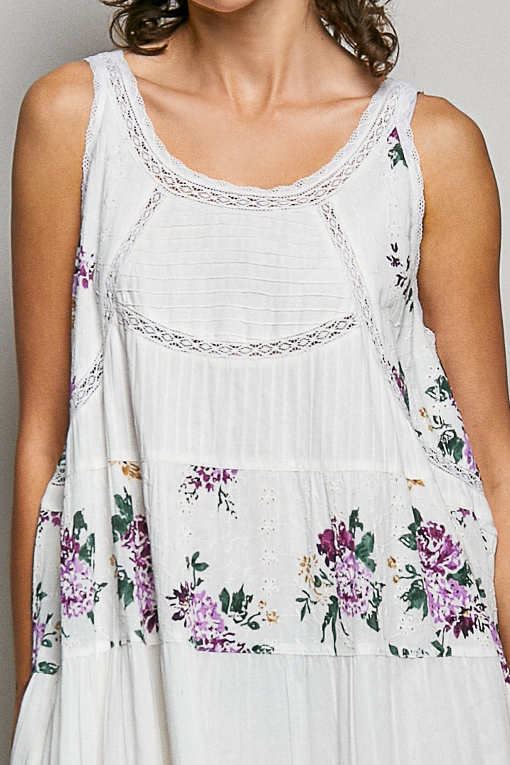 White sleeveless top with floral embroidery and patterns
