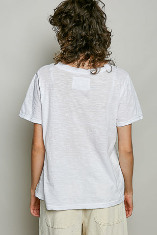 Person wearing a plain white t-shirt against a neutral background