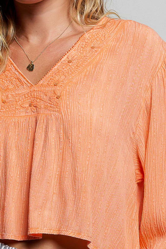Close-up of an orange blouse with a blurred background