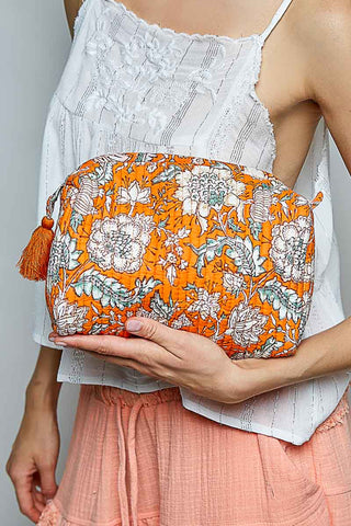 A women holding an orange cosmetic case.
