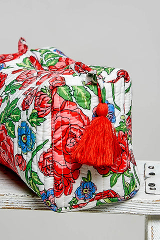 Floral-patterned bag with a red tassel on a light gray background