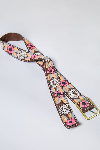 Floral patterned strap with a gold buckle on a light gray background