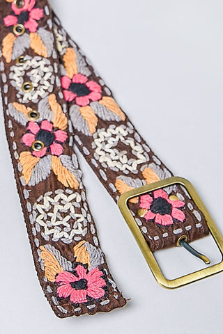 Embroidered floral belt with a gold buckle on a white background