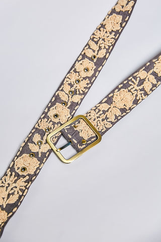 Floral patterned belt with a gold buckle on a light gray background