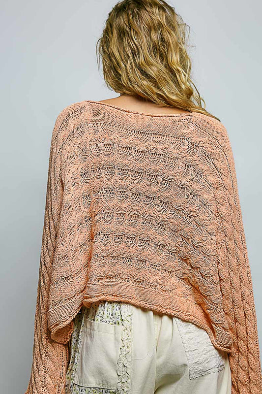 women wearing a bright pink knit sweater on a grey background