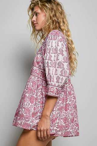 Women wearing a pink floral top against a neutral background.