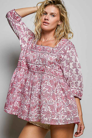 Women wearing a pink floral top against a neutral background.