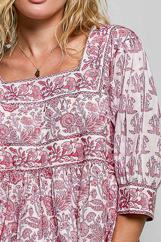 Women wearing a pink floral top against a neutral background.