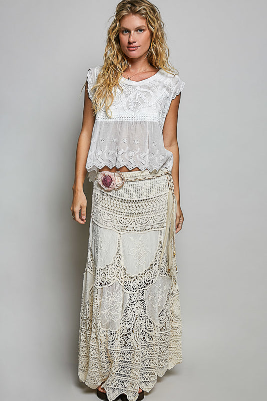 Woman wearing a white lace dress with a gray background