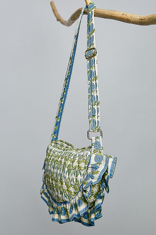 Green and blue patterned handbag with a strap on a gray background