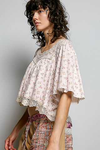 Woman wearing a floral blouse with a plain background