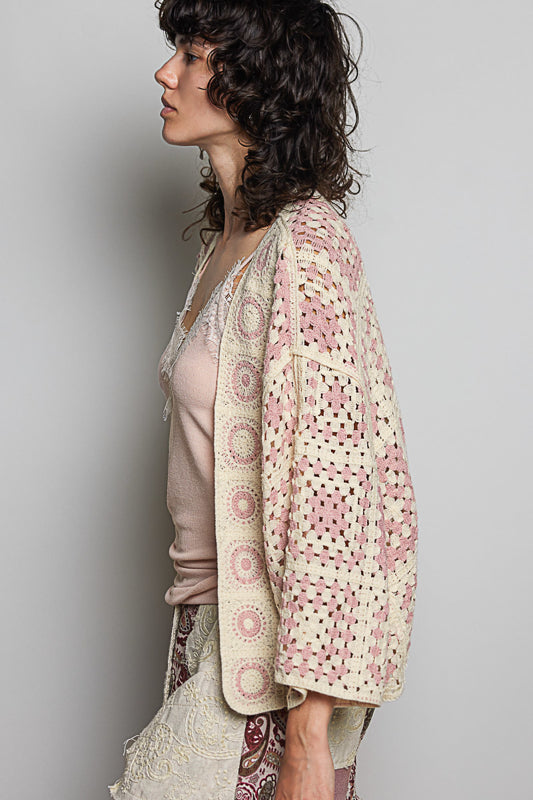 Woman wearing a patterned kimono-style garment against a plain background