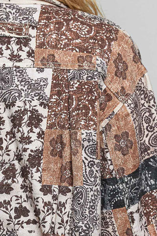 Close-up of a patchwork blouse featuring various botanical and paisley prints in brown, beige, black, and white.