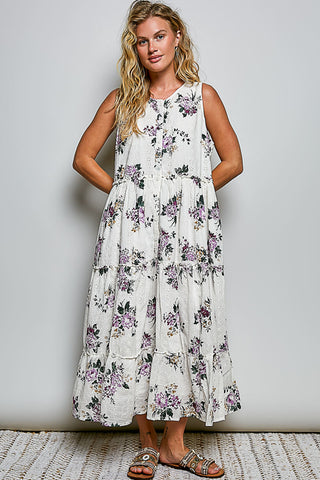 A women wearing a floral maxi dress against a neutral background.