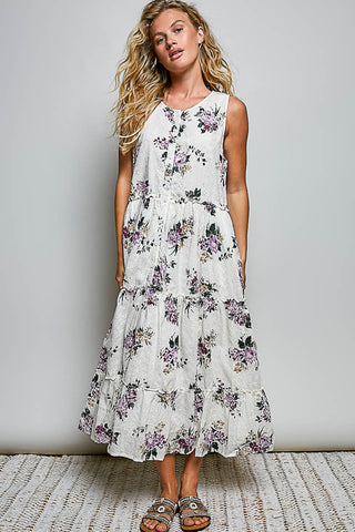 A women wearing a floral maxi dress against a neutral background.