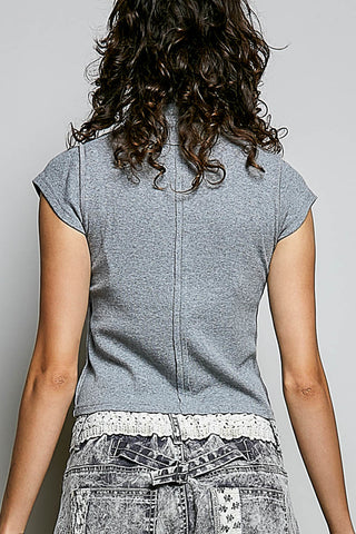 Back view of a woman wearing a heather gray short-sleeve top and distressed denim bottoms against a plain light gray background.