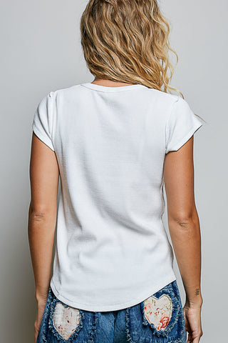 A woman viewed from behind wearing a plain white short-sleeve t-shirt and distressed blue denim jeans with heart-shaped patch details.