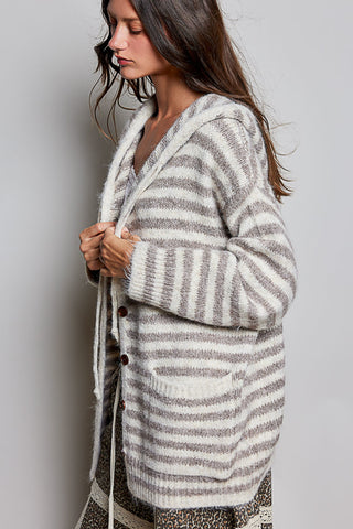 A woman wearing a fuzzy knit cardigan with horizontal gray and off-white stripes, shown from the side against a plain light gray background.