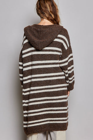 A person shown from the back wearing a brown and off-white horizontally striped hooded cardigan or sweater against a plain light gray studio background.