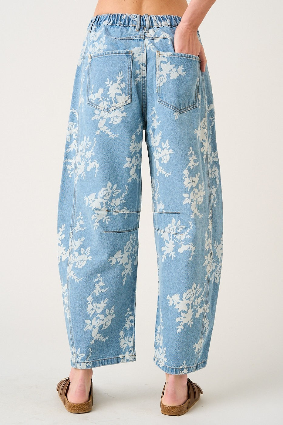 Light blue floral-patterned jeans worn by a person on a white background