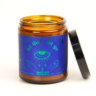 Candle jar with a blue label featuring text and symbols on a white background