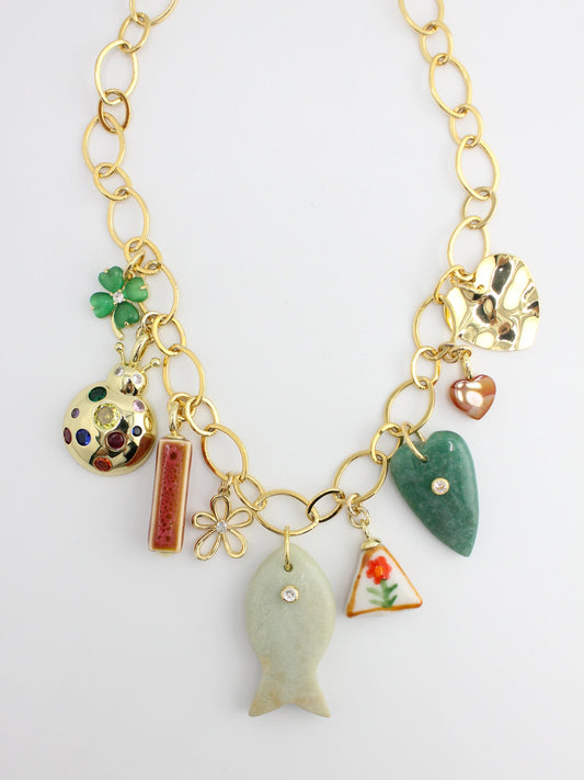 Gold necklace with various charms on a white background