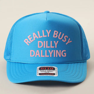 Blue trucker hat with pink text on a beige background