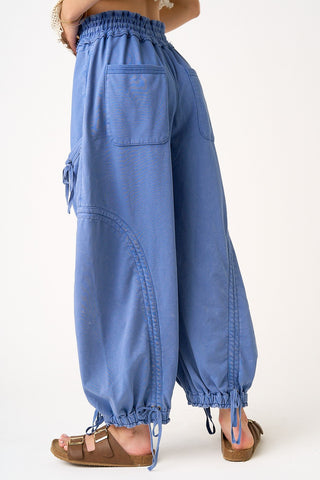 Blue wide-leg pants worn by a person on a white background