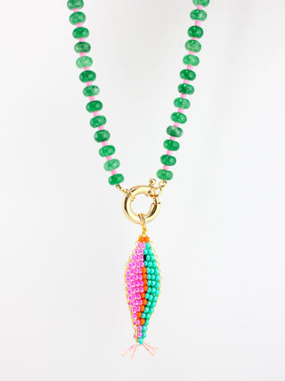 Necklace with green beads and a colorful fish-shaped pendant on a white background