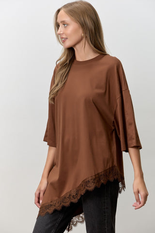 Women wearing a brown t shirt with Lace Trim against a neutral background. 