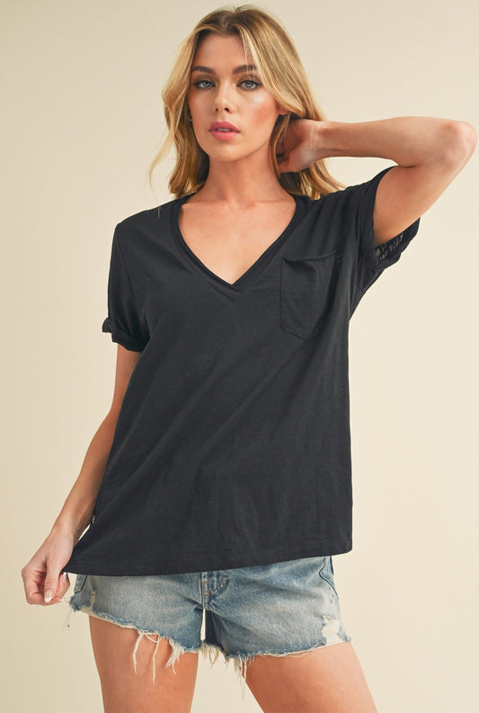 Woman wearing a black oversized t-shirt and denim shorts on a beige background