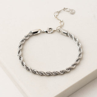 a silver twist bracelet on a table