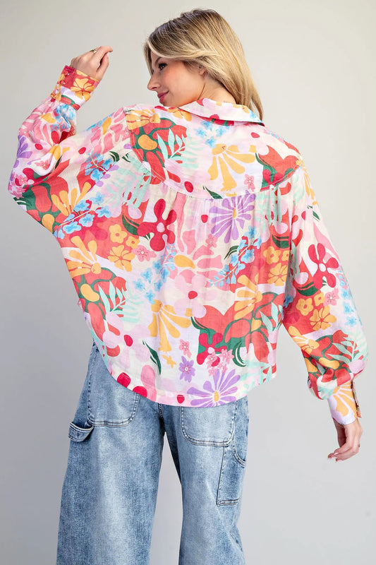 Woman wearing a colorful floral blouse with a plain background