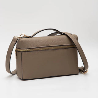 A taupe brown pebbled leather handbag with a top handle, a detachable shoulder strap, and a gold zipper, shown on a light gray background.