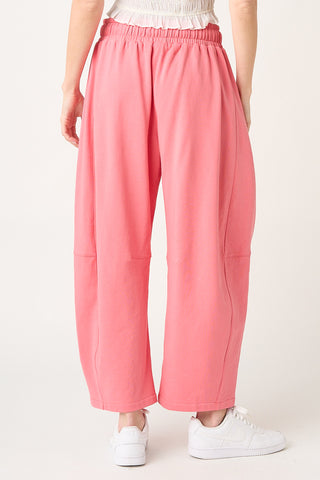 Person wearing pink sweatpants on a neutral background.