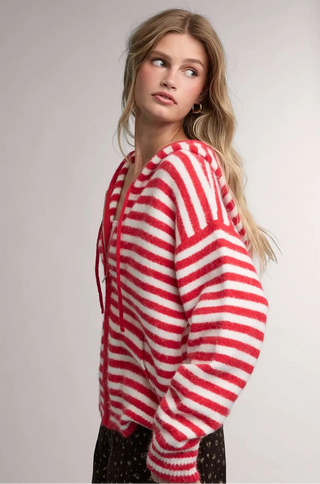 Women wearing a striped hoodie against a neutral background.