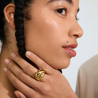 Close-up of a person wearing a gold ring on their hand