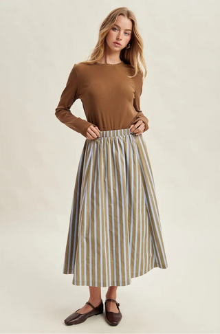 A women wearing a striped skirt against a neutral background.
