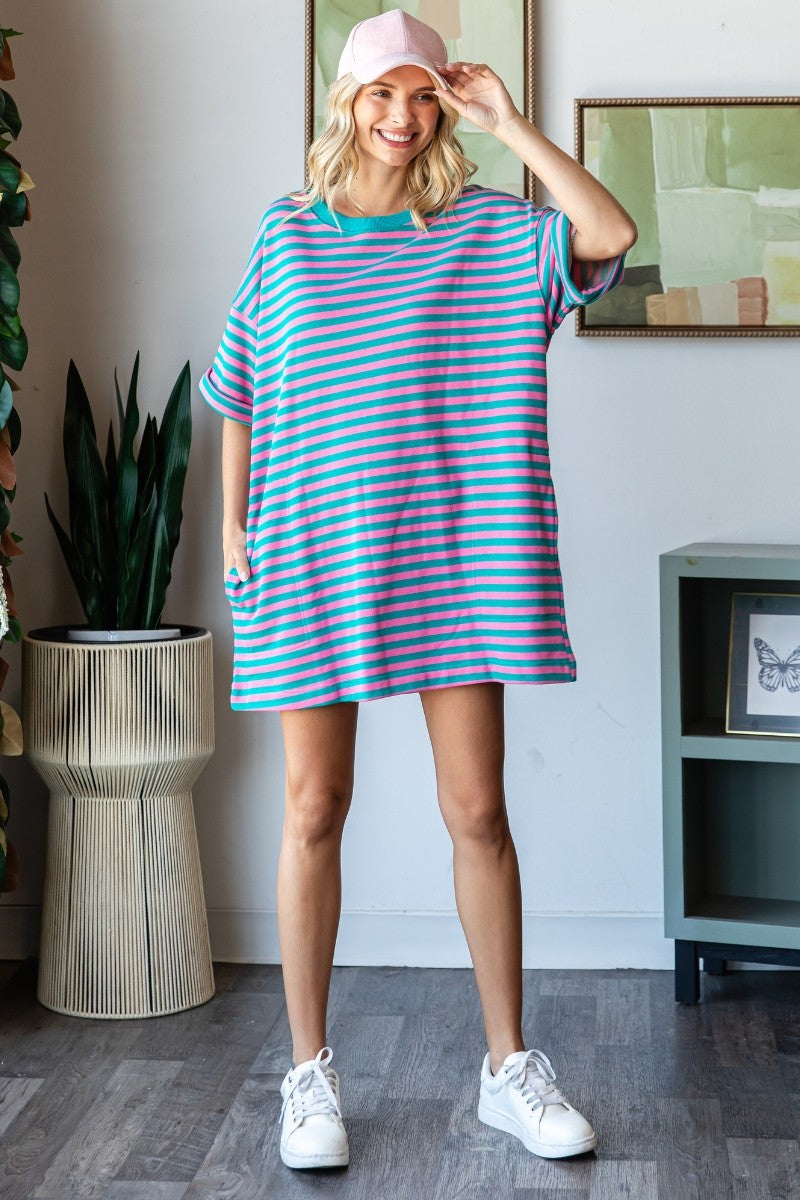 Woman wearing a striped dress and pink cap indoors