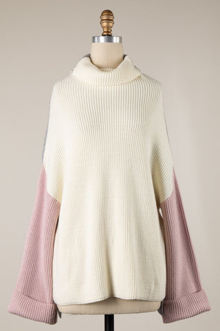 Cream and pink sweater on a mannequin against a neutral background