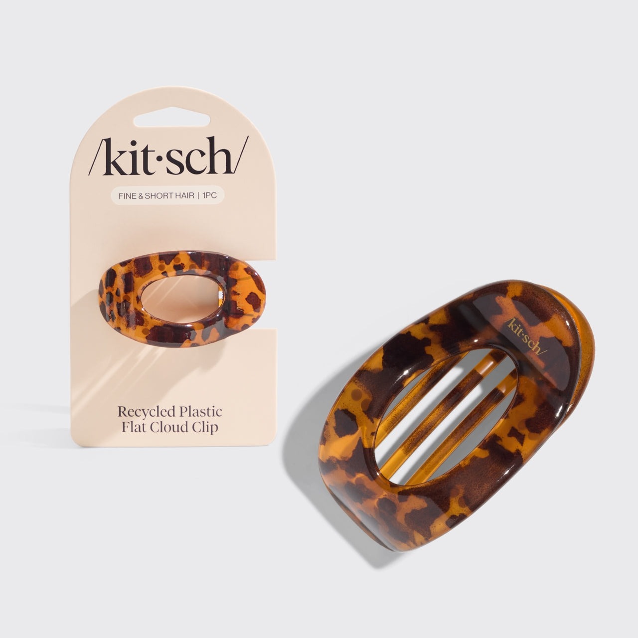 Tortoise shell patterned flat cloud clip with 'kit'sch' packaging on a light gray background