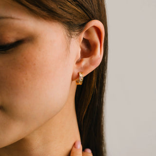 a women modelling a pair of diamond gold hoop earrings.